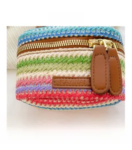 Detail shot of colorful woven texture and gold zipper on a mini crossbody bag