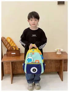 Detail of color-block kids dinosaur backpack with cute bear print and round side pouch