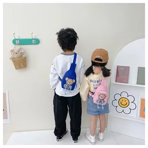 Rear view of a child wearing a blue cartoon bear chest bag with adjustable strap