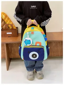 Detail showing kids color-block dinosaur backpack with cute bear face and yellow accents