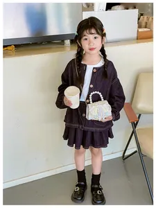 Girl's white embroidery shoulder bag with pearl handle and tassel detail close-up