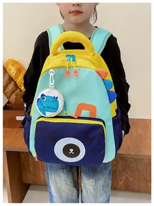 Detail of color-block dinosaur backpack with cartoon bear pocket and small detachable pouch