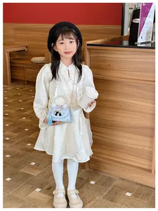 Détail d'une robe en dentelle blanche pour filles avec sac panda perlé bandoulière