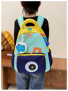 Close-up of a child wearing the dinosaur backpack with bear pocket and mini bag