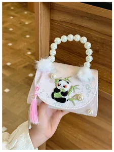 Détail d'un sac enfant en soie rose avec broderie panda et anse perles