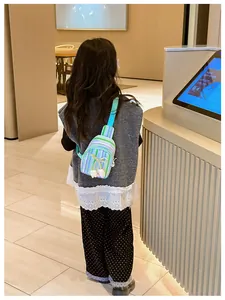 Rear view of a child wearing a colorful striped crossbody bag with bow and plush charms