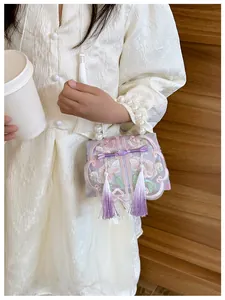 Detail of light purple butterfly bow handbag with pearl handle and floral embroidery