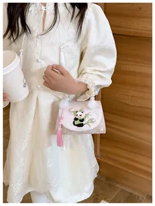 Détail du sac enfant rose avec broderie panda, poignée perle et décorations à glands