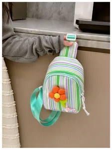 Detail of a mini striped chest bag for girls featuring a 3D orange flower and LOVE charm