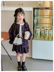 Detail of dark purple denim jacket and pleated skirt set for girls in cafe setting