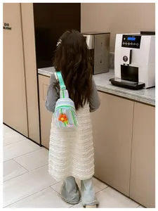 Rear view of a girl wearing a purple striped crossbody chest bag with a yellow flower