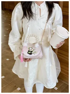 Détail du sac rose pour enfant avec broderie panda et poignée en perles