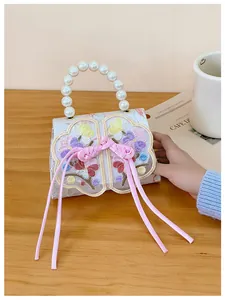 Detail of floral embroidery and white pearl handle on an elegant vintage-style handbag