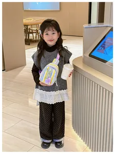 Detail view of child wearing colorful striped crossbody chest bag with tulip charm