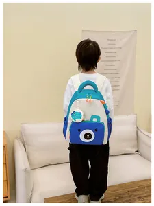 Detail of cute dinosaur kids backpack with blue bear pocket and hanging mini round pouch