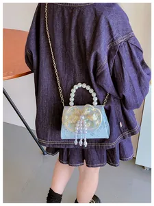 Detail of light blue girls' handbag with floral embroidery and pearl fringe charms
