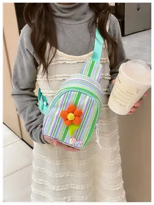 Detail of a colorful striped crossbody bag for girls with an orange flower and LOVE patch