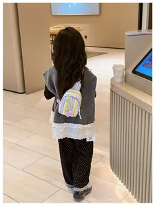 Close-up of girl wearing a yellow and blue striped crossbody bag with tulip charm