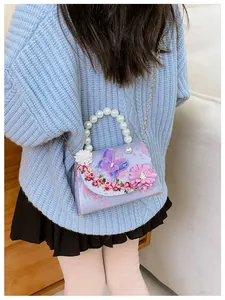 Détail du sac floral pour enfants avec poignée en perles et charm papillon mauve