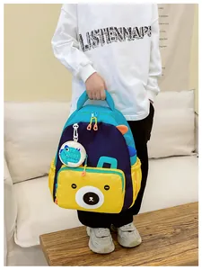 Detail view of colorful kids dinosaur backpack with cute bear pocket and side storage