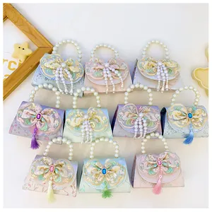 Macro shot of colorful girls bags with lace embroidery, pearl handles, and silk tassels