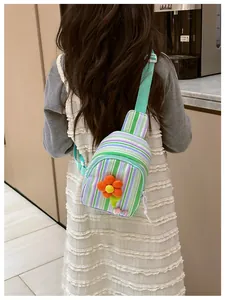 Detail of striped girl's crossbody chest bag with plush orange flower and LOVE lettering