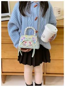 Detail of floral embroidery and pearl handle on green Chinese style children crossbody bag