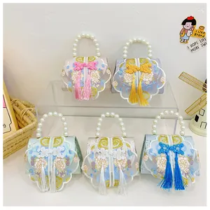 Detail view of mini Chinese style embroidered handbags with pearl handles and silk tassels