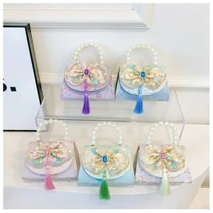 Detailed row of mini pearl handle bags with lace bows and colorful silk tassels