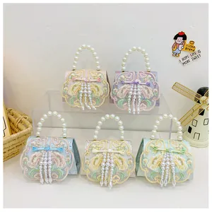 Detail of colorful mini embroidered bags with pearl tassels and top handles for girls
