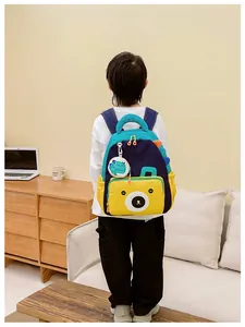Kid wearing a colorful dinosaur backpack with bear pocket in a cozy home setting