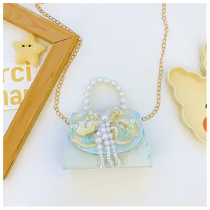 Detail of light blue kids handbag featuring pearl handle and lace bow decoration