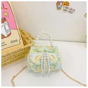 Detail of mint green girls crossbody bag with floral embroidery and pearl tassel fringe