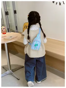 Rear view of child wearing blue striped chest bag with green fruit charm detail