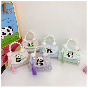Détail de la broderie panda sur mini sacs à main avec poignées en perles et pompons