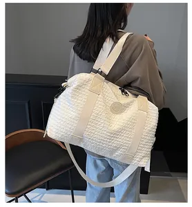 Back view of a white large capacity gym bag with honeycomb texture on a female model