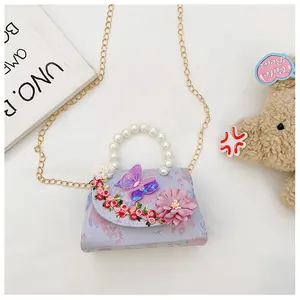 Détail d'un sac pour enfant avec papillon 3D, perles et bandoulière dorée