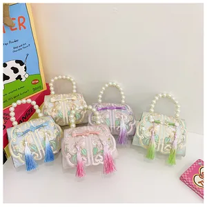 Close-up of traditional embroidery, tassel detail, and pearl handles on five silk bags