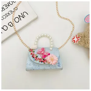 Détail de broderie florale et poignée en perles sur sac bandoulière bleu clair fille