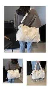 Detailed view of white quilted travel bag with bubble texture and adjustable strap