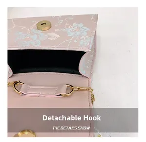 Detail of pink floral handbag showing golden magnetic snap and detachable metal hook