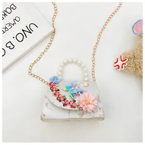 Détail de broderies florales et papillon 3D sur un sac à main en tissu pour enfant