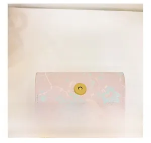 Close-up of pink floral shoulder bag with golden magnetic clasp and fine stitching details