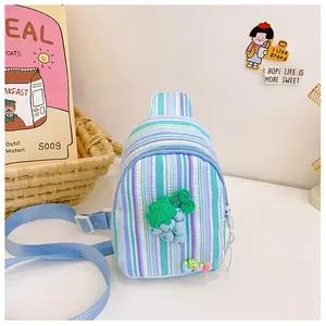 Detail of striped kids crossbody bag with 3D grape charm and adjustable blue strap
