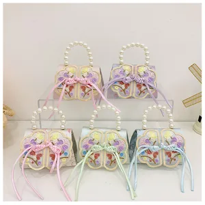 Detail view of colorful Chinese embroidery handbags with pearl handles and floral silk patterns