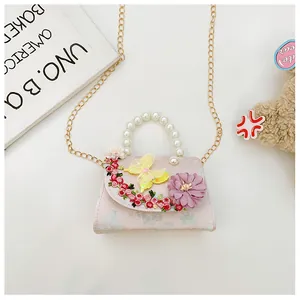 Détail du sac floral rose avec anse en perles et broderie papillon 3D