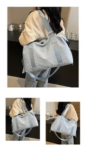 Close-up of light blue travel bag featuring crinkled fabric texture and logo detail