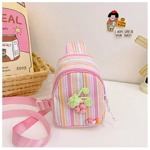 Detail of colorful striped crossbody bag for girls featuring a cute 3D grape pendant