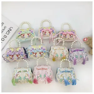 Detail of diverse Chinese style mini bags featuring floral embroidery and pearl handles