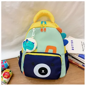Detail of colorful dinosaur backpack for kids with bear face pocket and charm